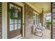 Charming front porch featuring a wreath, outdoor seating, and a brick facade at 626 Oakbourne Way, Woodstock, GA 30188