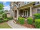 Inviting front porch with stone accents, manicured shrubs, and outdoor seating at 626 Oakbourne Way, Woodstock, GA 30188