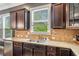 Bright kitchen features dark wood cabinetry, stainless appliances, and granite counters, offering style and function at 626 Oakbourne Way, Woodstock, GA 30188