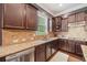 Close-up of kitchen featuring stainless steel appliances, dark wood cabinets, and granite countertops at 626 Oakbourne Way, Woodstock, GA 30188