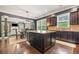 Open concept kitchen featuring a dining table with seating, a central island and dark wood cabinetry at 626 Oakbourne Way, Woodstock, GA 30188