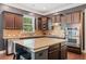 Kitchen features stainless appliances, an island with seating, and dark wood cabinetry providing storage and style at 626 Oakbourne Way, Woodstock, GA 30188