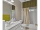 Bright bathroom featuring a white vanity, large mirror, and shower-tub combination with neutral-toned shower curtain at 1812 Mountain Lake Nw Dr, Kennesaw, GA 30152
