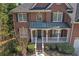 Close-up of a classic brick home featuring a welcoming front porch with white columns and manicured landscaping at 1812 Mountain Lake Nw Dr, Kennesaw, GA 30152