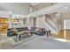 Spacious living room with a large black sofa, staircase, and view into the kitchen at 1812 Mountain Lake Nw Dr, Kennesaw, GA 30152
