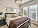 Bedroom features a bed with neutral bedding, white brick accent wall, and natural light from two windows at 1923 Prospect Park Ln, Decatur, GA 30033