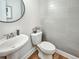 Chic powder room with a pedestal sink and horizontally tiled wall at 1923 Prospect Park Ln, Decatur, GA 30033