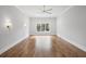 Light-filled bedroom with hardwood floors, sconces, a ceiling fan, and large windows at 584 Indian Hills Pkwy, Marietta, GA 30068
