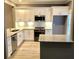 Well-lit kitchen with white cabinets, stainless steel appliances, granite countertops, and wooden floors at 1975 Hoods Fort Nw Cir # 24, Kennesaw, GA 30144