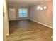 Open living room with laminate flooring, a window with blinds, and modern chandelier lighting at 1975 Hoods Fort Nw Cir # 24, Kennesaw, GA 30144
