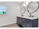 Modern bathroom featuring a dual sink vanity with black cabinets and gold hardware at 3040 Greenfield Dr, Marietta, GA 30068