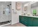 Modern bathroom featuring double vanity with elegant green cabinets and a glass-enclosed shower at 3040 Greenfield Dr, Marietta, GA 30068