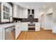 Kitchen featuring white cabinets, stainless steel appliances, modern backsplash, and hardwood floors at 3040 Greenfield Dr, Marietta, GA 30068