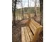 Relax on this wooden bench with a lake view surrounded by natural woodland beauty at 629 Gold Valley Pass, Canton, GA 30114