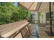 Image of wood deck with table, chairs, umbrella, built-in bench seating, and view of greenery in background at 629 Gold Valley Pass, Canton, GA 30114
