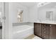 Bathroom featuring a soaking tub with tile surround, vanity with storage, and ample natural light at 7545 Roseberry Way, Lithonia, GA 30038
