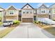 Charming townhome with a spacious driveway and attached two-car garage with manicured shrubs and plants at 7545 Roseberry Way, Lithonia, GA 30038