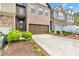 Beautiful townhome featuring a large driveway, two-car garage, and manicured landscaping enhancing curb appeal at 7545 Roseberry Way, Lithonia, GA 30038