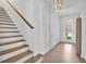Bright and open foyer with hardwood floors, a staircase with wooden railing, and modern lighting at 7545 Roseberry Way, Lithonia, GA 30038