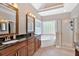 Well-lit bathroom featuring a double vanity, soaking tub, and glass-enclosed shower at 7801 Windswept Way, Douglasville, GA 30135