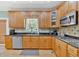 Close up view of the kitchen showcasing black counters, wooden cabinets, and stainless steel appliances at 7801 Windswept Way, Douglasville, GA 30135