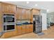 Modern kitchen with stainless steel appliances, dark countertops, and warm wood cabinets at 7801 Windswept Way, Douglasville, GA 30135