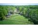 Aerial view of a beautiful estate featuring lush green pastures, a pond, and mature trees at 8132 Union Hill Rd, Canton, GA 30115
