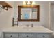 Bathroom featuring a white vanity, framed mirror, shelves, and tile floors at 8132 Union Hill Rd, Canton, GA 30115