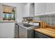 Laundry room featuring modern appliances, decorative tile backsplash, and butcher block countertop at 8132 Union Hill Rd, Canton, GA 30115