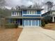 Charming two-story home featuring a blue exterior, well-maintained landscaping, and a spacious driveway at 2331 Bouldercliff Se Way, Atlanta, GA 30316