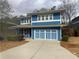 Charming two-story home featuring a blue exterior, well-maintained landscaping, and a spacious driveway at 2331 Bouldercliff Se Way, Atlanta, GA 30316