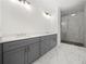 Bathroom featuring walk-in shower with marble tile, and double sink vanity with light countertops at 3920 Bellair Dr, Marietta, GA 30066