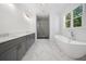 Elegant bathroom featuring double sink vanity, marble walk-in shower, and a freestanding tub under a window at 3920 Bellair Dr, Marietta, GA 30066