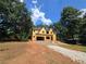 Exterior view of a two-story house under construction with a gravel driveway surrounded by lush trees and greenery at 3920 Bellair Dr, Marietta, GA 30066