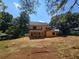 Back exterior view of two-story house under construction surrounded by an expansive yard with mature trees at 3920 Bellair Dr, Marietta, GA 30066