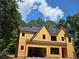 Exterior view of a two-story house under construction, showing the initial framework and roof against a backdrop of trees at 3920 Bellair Dr, Marietta, GA 30066