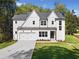 New two-story home with a concrete driveway and landscaped front yard and an attached garage at 3920 Bellair Dr, Marietta, GA 30066