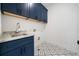 Laundry room with patterned tile flooring and navy blue cabinetry at 3920 Bellair Dr, Marietta, GA 30066