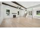 Bright, open living room boasts exposed beam ceiling, fireplace, and light wood floors, offering a modern yet rustic feel at 3920 Bellair Dr, Marietta, GA 30066