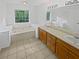 This bathroom features a double vanity, soaking tub under a window and tiled floors at 823 New Hope Rd, Mcdonough, GA 30252