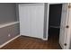 Bedroom featuring wood-look flooring and a spacious closet with folding doors at 9399 Whaleys Lake Ln, Jonesboro, GA 30238