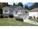 Two-story home featuring an attached garage, a manicured lawn and mature trees at 9399 Whaleys Lake Ln, Jonesboro, GA 30238