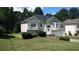 Two-story home featuring an attached garage, a manicured lawn and mature trees at 9399 Whaleys Lake Ln, Jonesboro, GA 30238