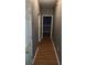 Hallway with wood-look flooring, neutral walls, and white trim throughout the home at 9399 Whaleys Lake Ln, Jonesboro, GA 30238