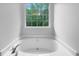 Bathroom featuring a bright tub next to a window at 131 Diamond Ct, Carrollton, GA 30116