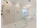 Bathroom featuring a frameless glass shower, soaking tub, and stylish tile design at 3735 Tamiami Trl, Cumming, GA 30041