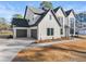 Side view of a white two story home with a three car garage and manicured landscaping at 3735 Tamiami Trl, Cumming, GA 30041
