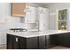 Close up of a modern kitchen with stainless steel appliances, white cabinets and black kitchen island at 3735 Tamiami Trl, Cumming, GA 30041