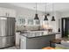 Well-lit kitchen boasts stainless steel appliances, light countertops, a kitchen island and modern pendant lighting at 611 King Arnold St, Atlanta, GA 30354