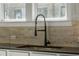 Close-up showcasing a modern kitchen sink with a pull-down faucet and a neutral-toned tiled backsplash at 611 King Arnold St, Atlanta, GA 30354